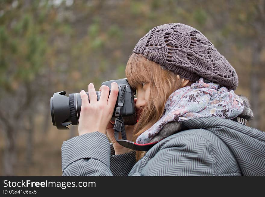 Young girl photographing something in the park. Young girl photographing something in the park