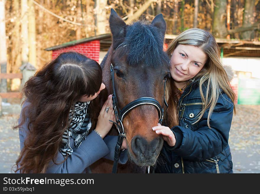 Two girls playing with horse