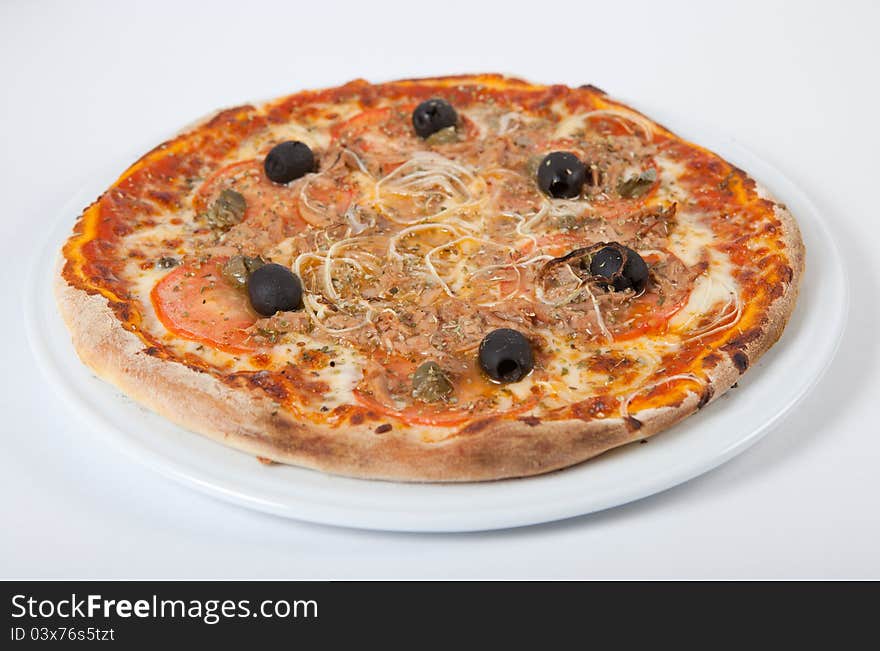 Round fresh pizza on white plate