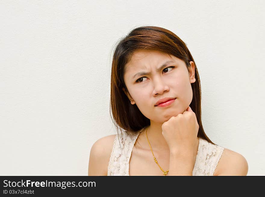 Young cute asian girl thinking on white background