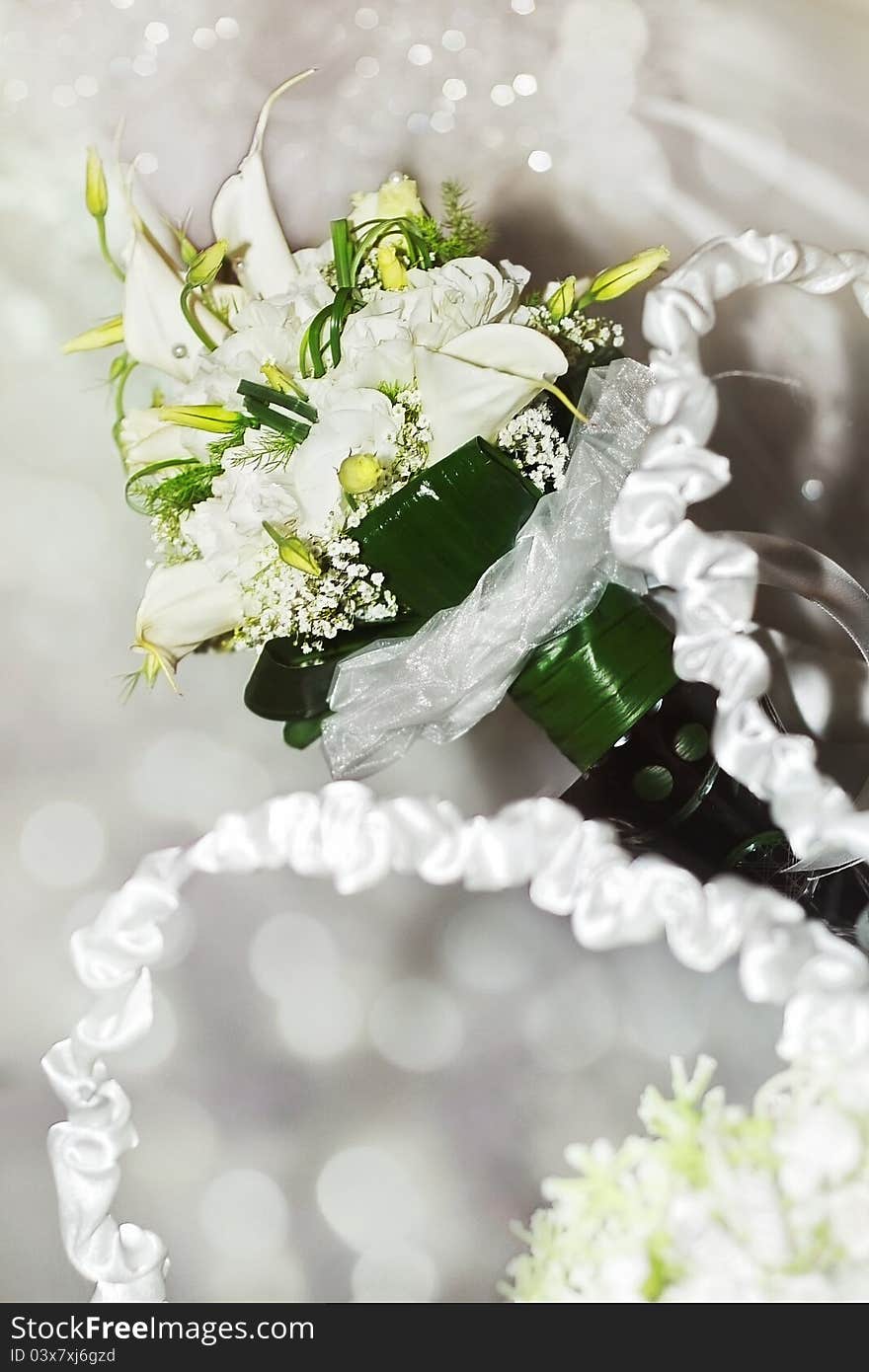 A white arum lily bouquet on sparkly, festive background. A white arum lily bouquet on sparkly, festive background.