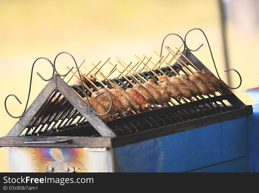 Grilled sausage over a hot barbecue grill.