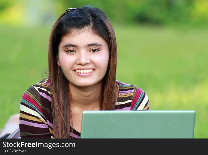 Asian female college student studying with a laptop computer. Asian female college student studying with a laptop computer