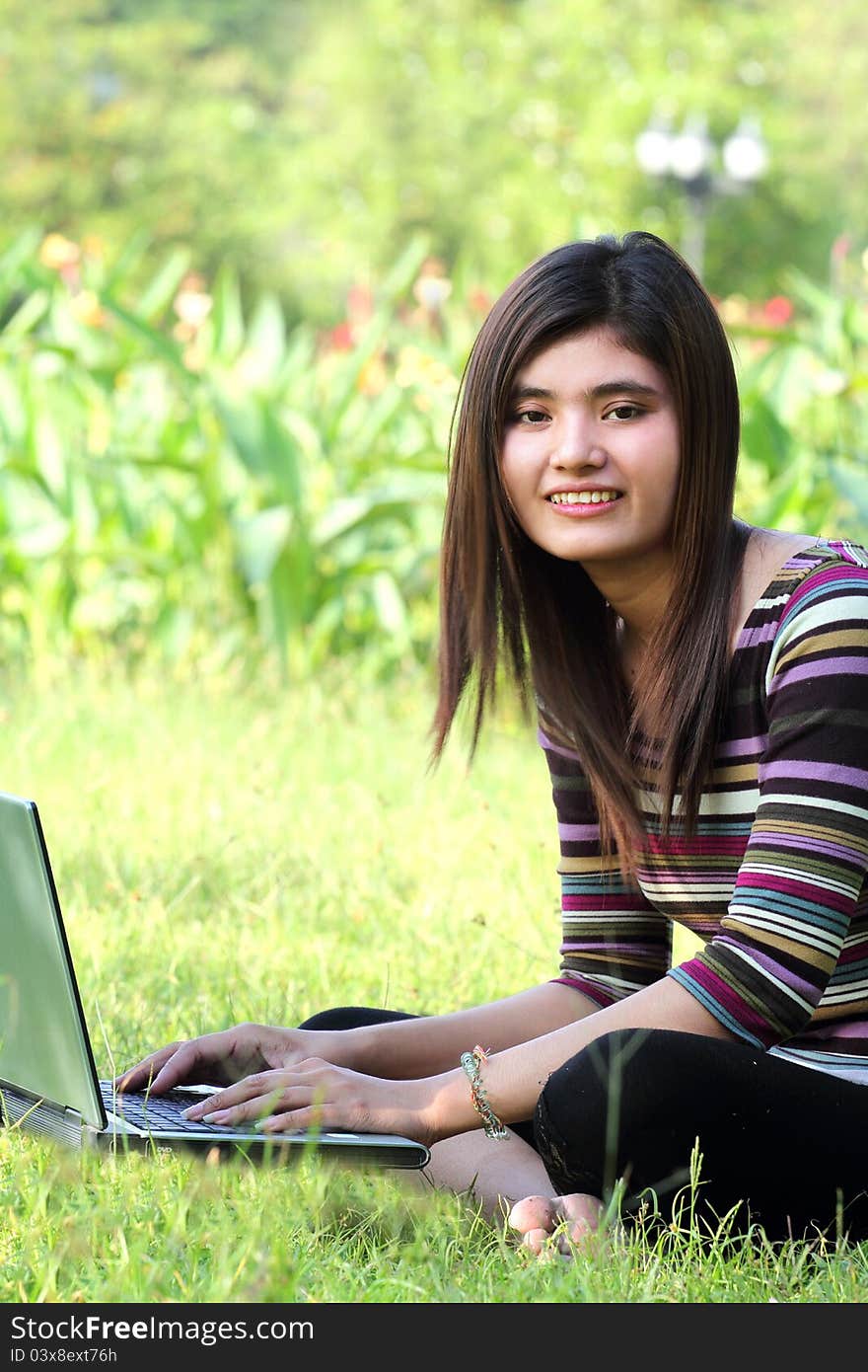 Asian female college student studying with a laptop computer. Asian female college student studying with a laptop computer