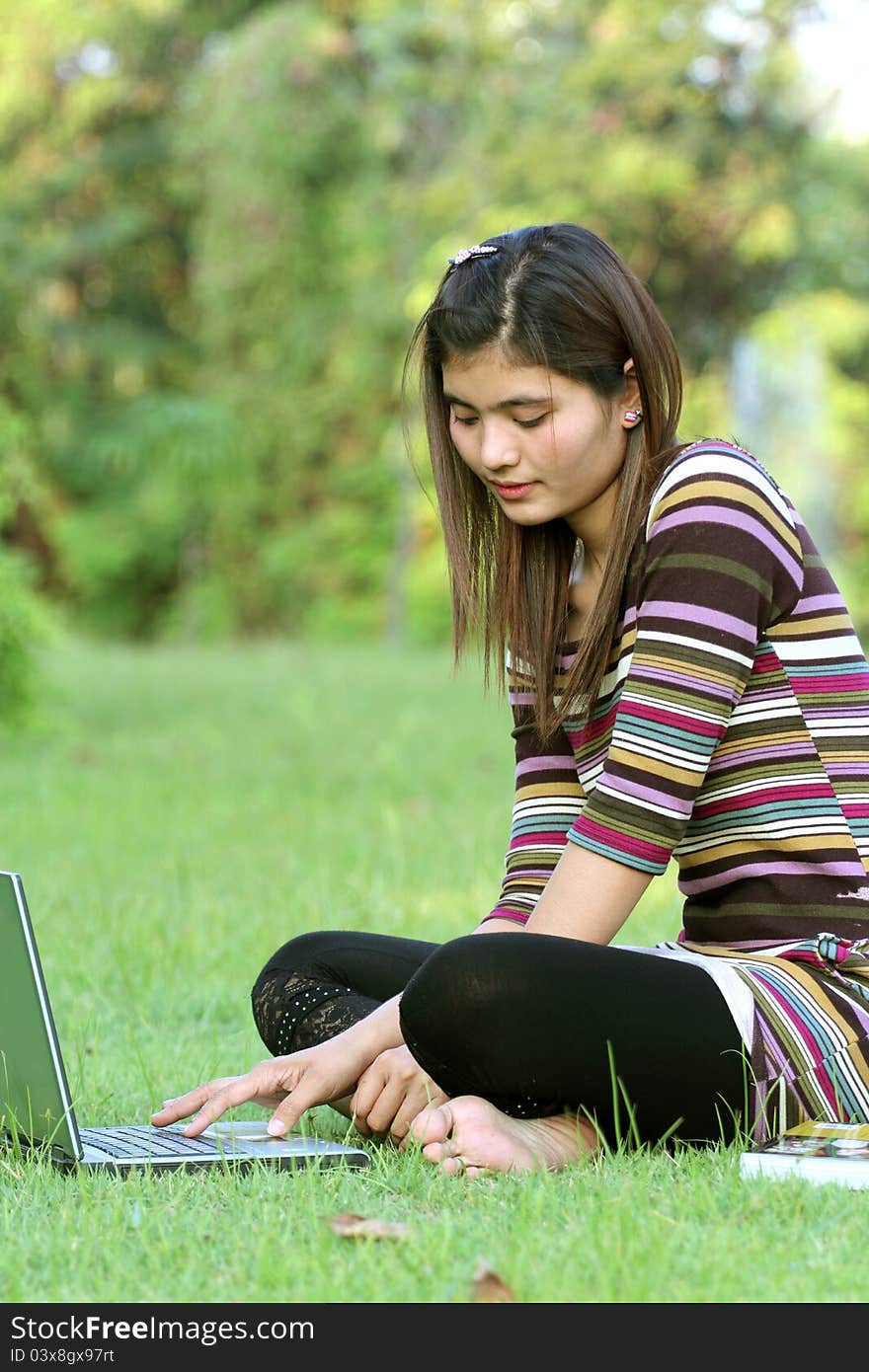 Asian female college student studying with a laptop computer. Asian female college student studying with a laptop computer