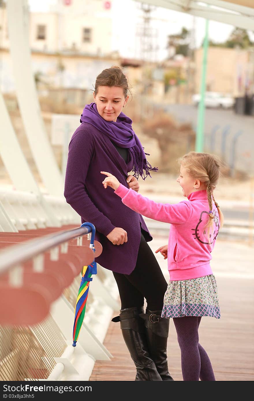 Mother and daughter walking on the bridge during the  day fall