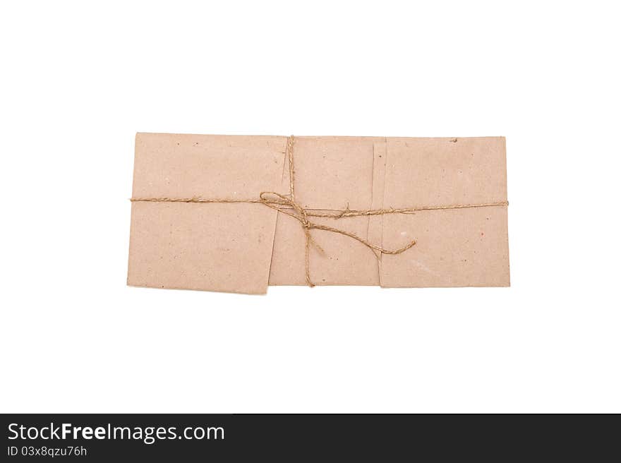 Isolated small parcel wrapped in brown paper with rough rope knot. Isolated small parcel wrapped in brown paper with rough rope knot