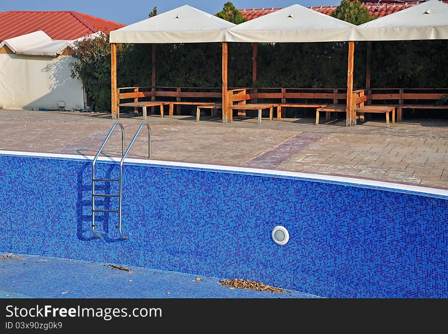 Empty blue pool and metallic stair near bar. Empty blue pool and metallic stair near bar