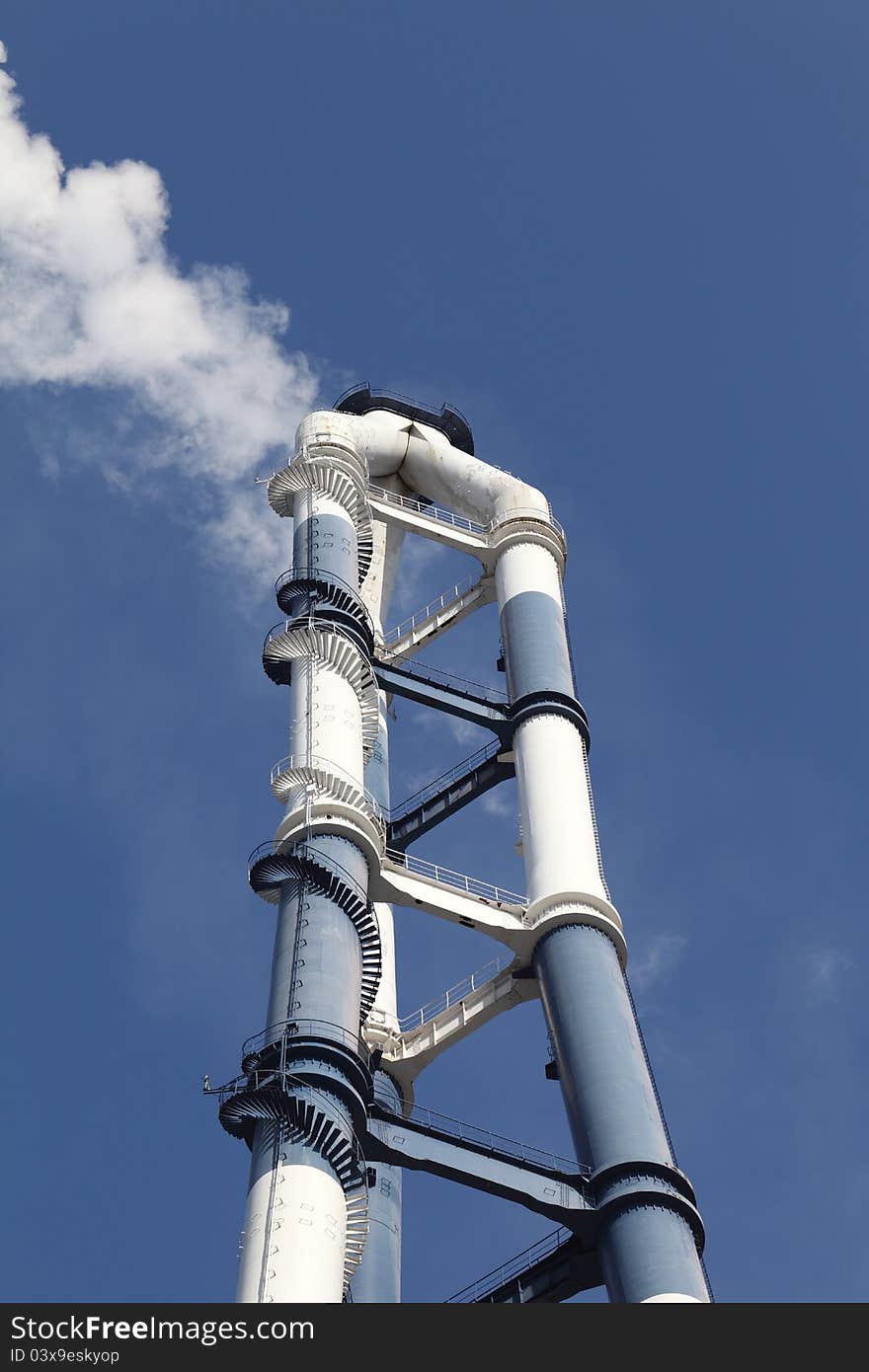 Smokestack with white smoke clear blue sky