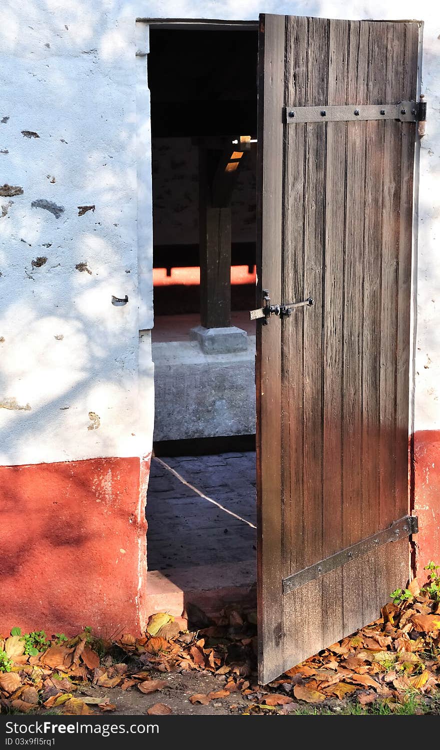 A wooden door ajar stone building on the outside. A wooden door ajar stone building on the outside