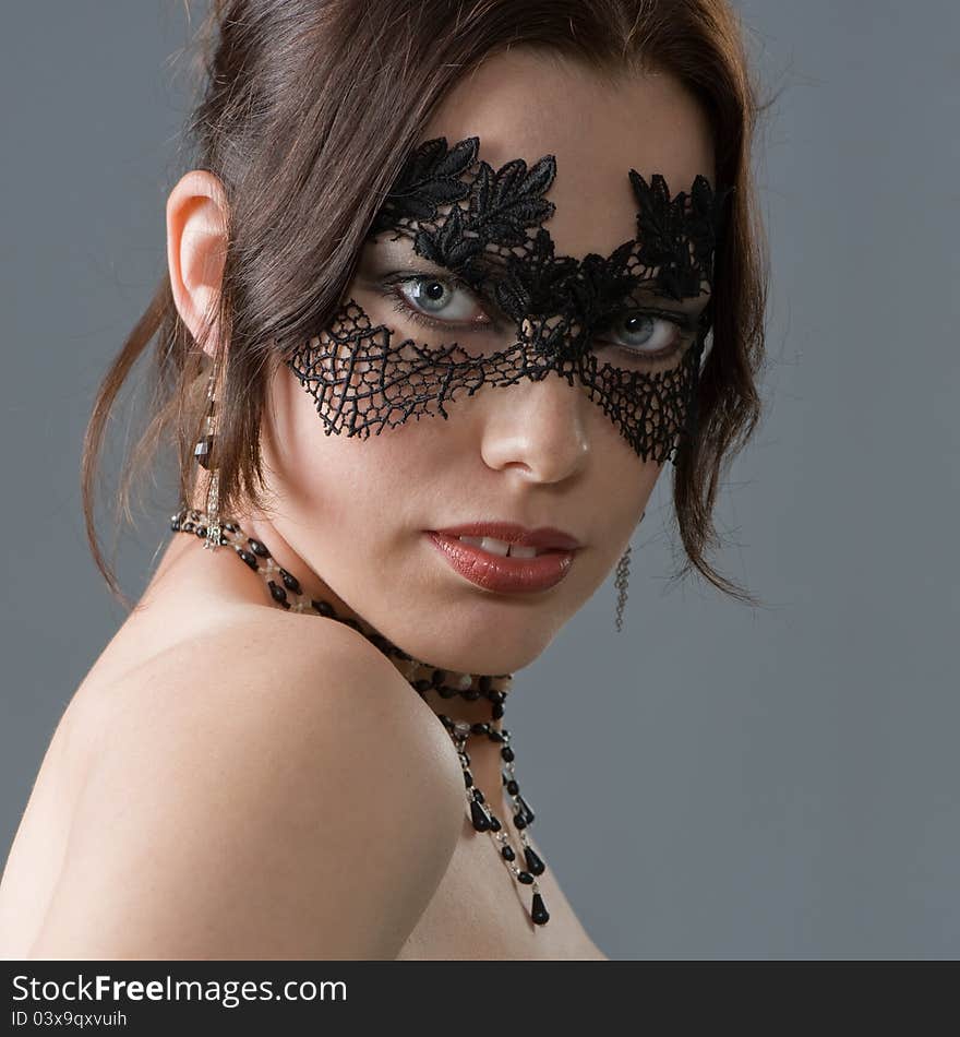 Portrait of an attractive young woman in elegant lace mask and accessories. Portrait of an attractive young woman in elegant lace mask and accessories