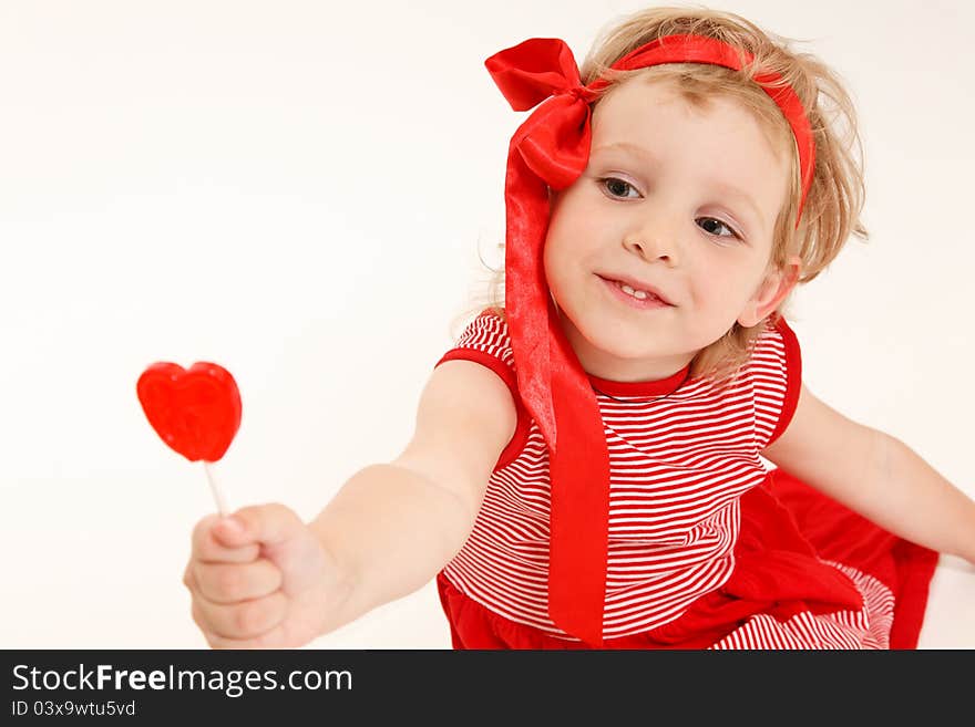 Little girl in a red dress with sweet heart. Little girl in a red dress with sweet heart.