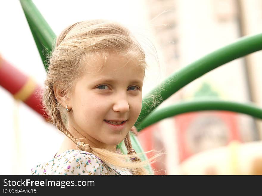 Portrait of a girl on a swing against