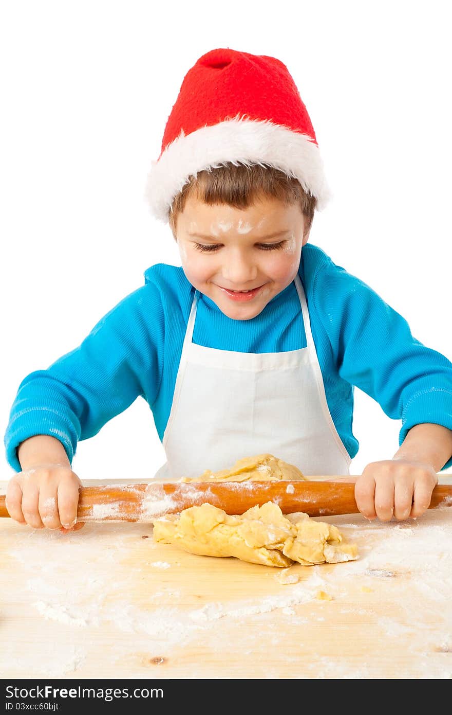 Smiling little boy kneading the dough for Christmas cooking, isolated on white. Smiling little boy kneading the dough for Christmas cooking, isolated on white