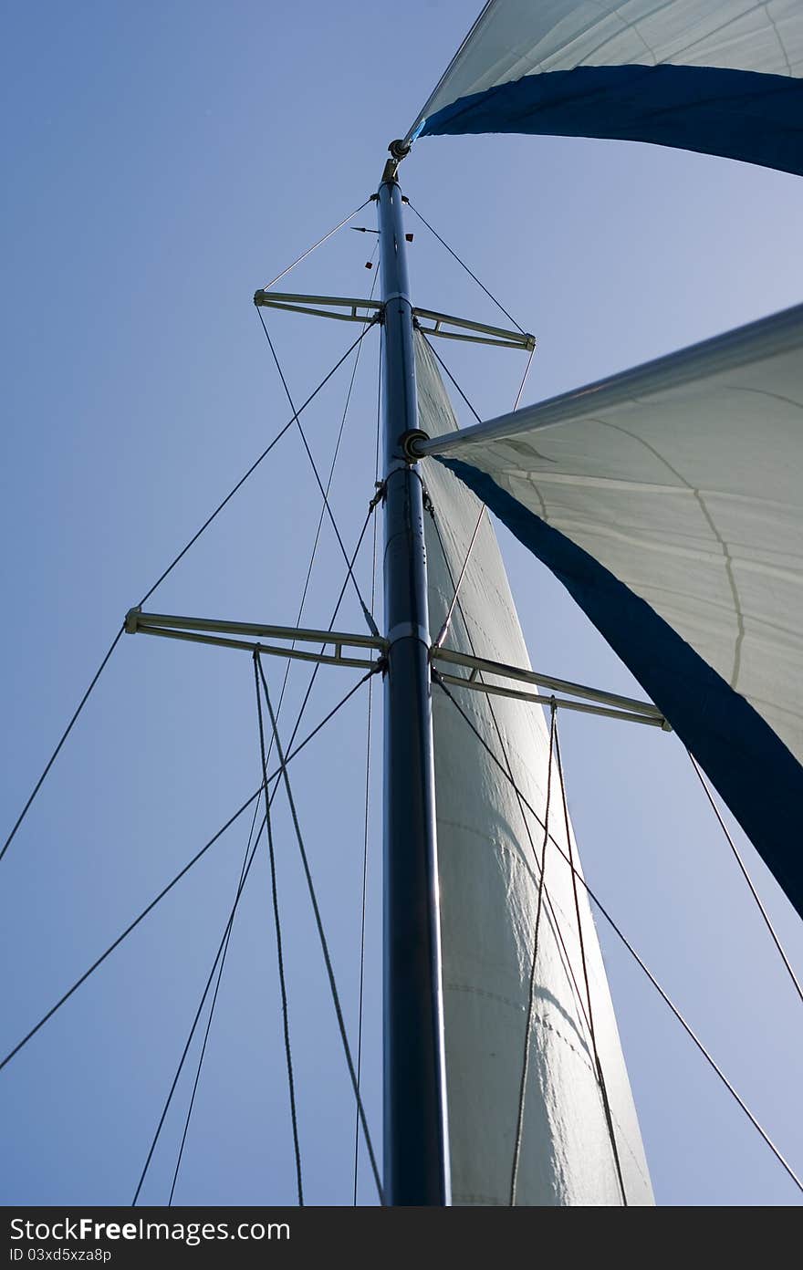 Sailing ship sails and masts at clear blue sky