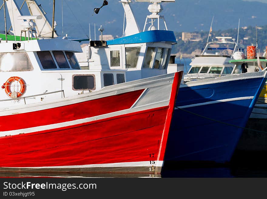 Red and blue fishing boats in the harbor