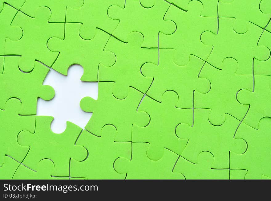 Green jigsaw puzzle with one missing piece. Green jigsaw puzzle with one missing piece