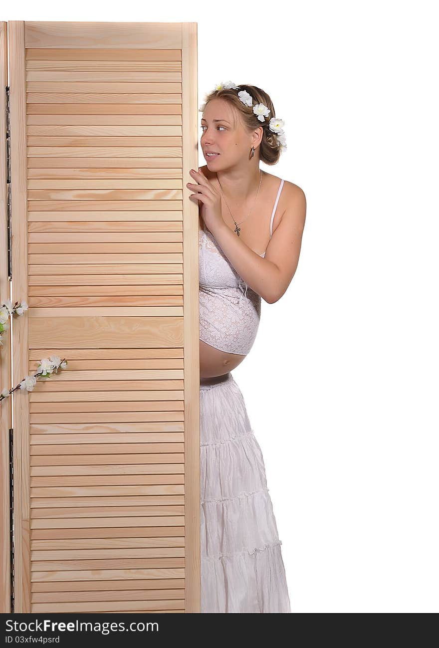 Pregnant woman peeks out from behind the screen