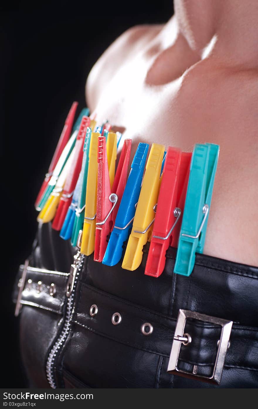 Woman dressed in a leather corset with colored clothespins attached to it. Woman dressed in a leather corset with colored clothespins attached to it