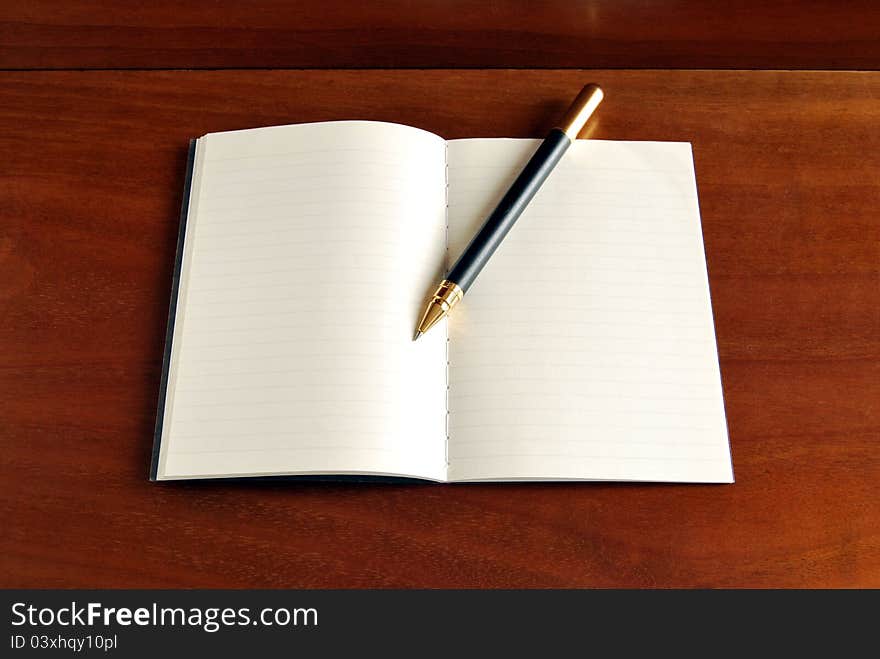 Notebook blank page on warm wood background. Notebook blank page on warm wood background