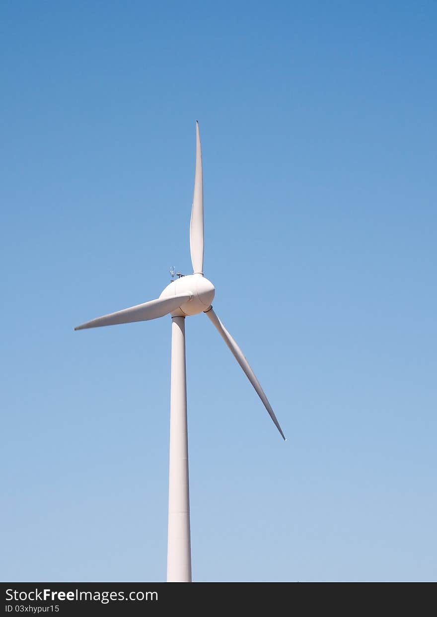 Wind turbine against a blue sky. Wind turbine against a blue sky.