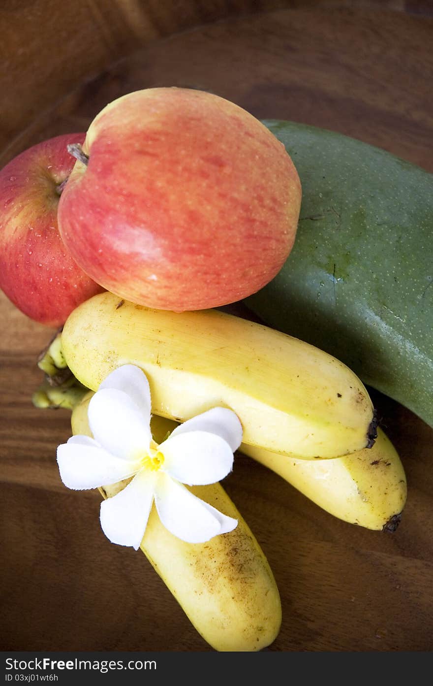 Tropical mixed fruits banana,mango and apple on wooden tray