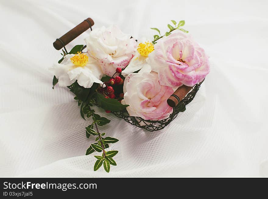 Pink roses and white camellias in a basket on white background