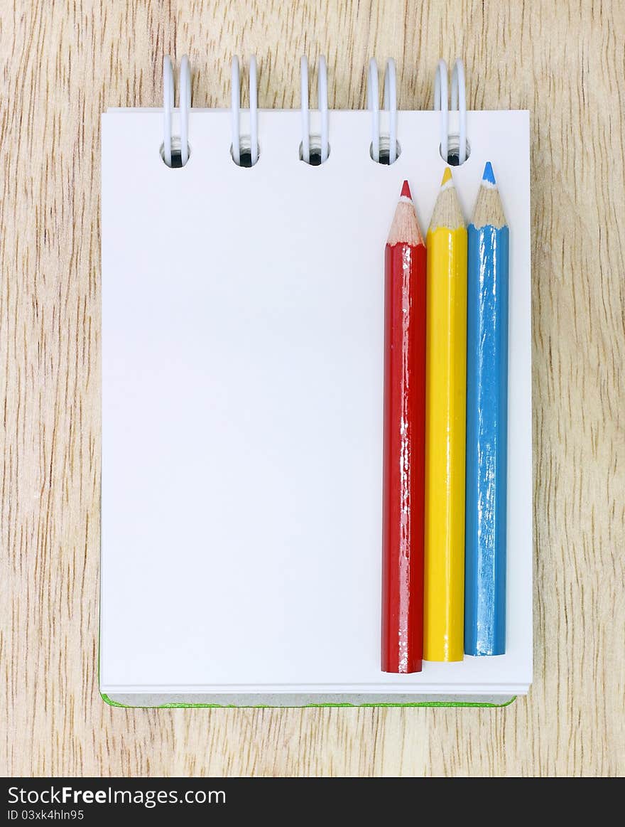 Color Pencils and notebook on Wood. Color Pencils and notebook on Wood