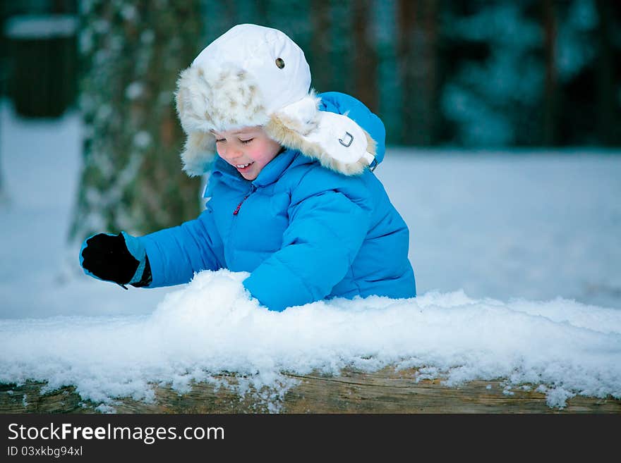 Portrait Of A Little Boy Playing With Snow