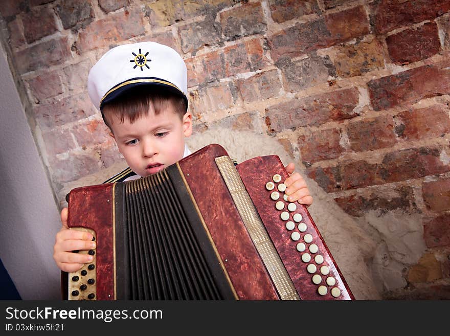 Portrait of a cute boy playing on accordion