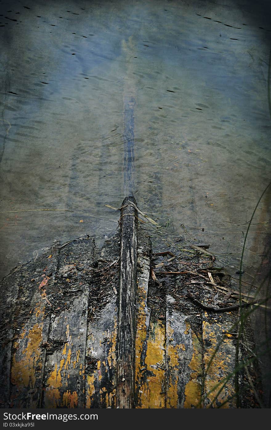 Small rowing boat partially sunken in the shallows of a pond. Small rowing boat partially sunken in the shallows of a pond.