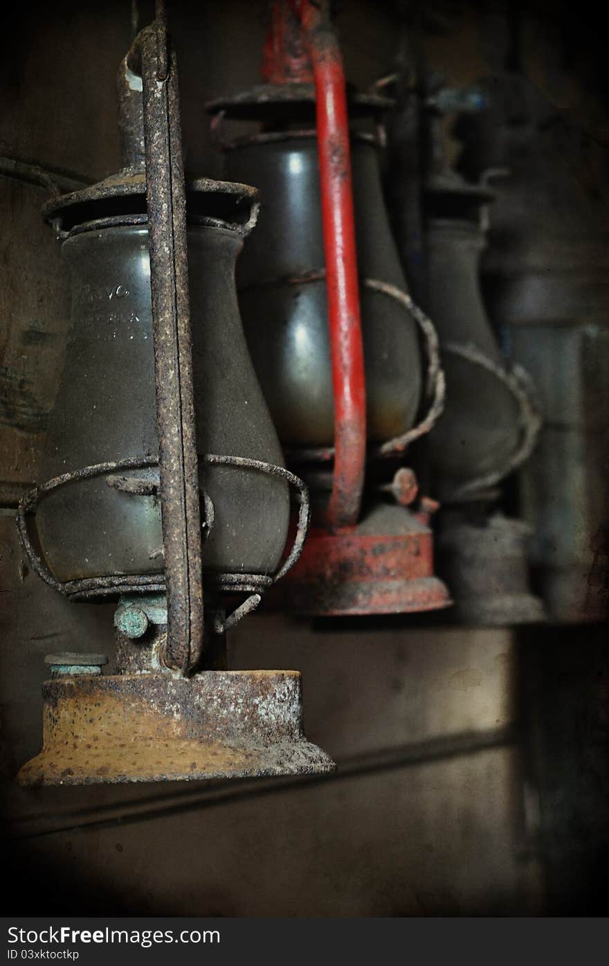 Old vintage lamps hanging in storage covered in dust.