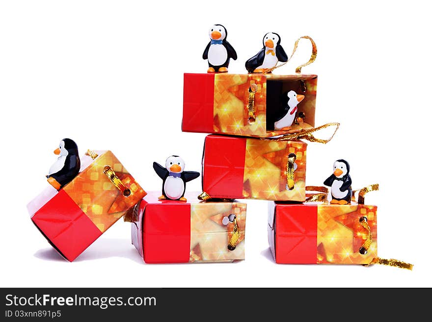 Happy penguins playing with gift boxes on white background