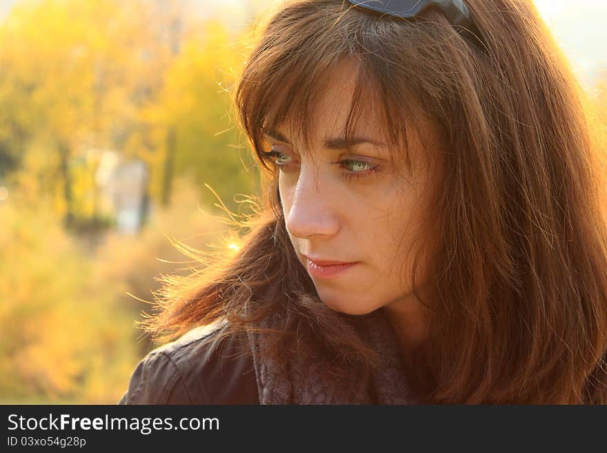 Portrait of a young women, with a thoughtful and pensive expression on her face, taken in the park in an autumn. Portrait of a young women, with a thoughtful and pensive expression on her face, taken in the park in an autumn