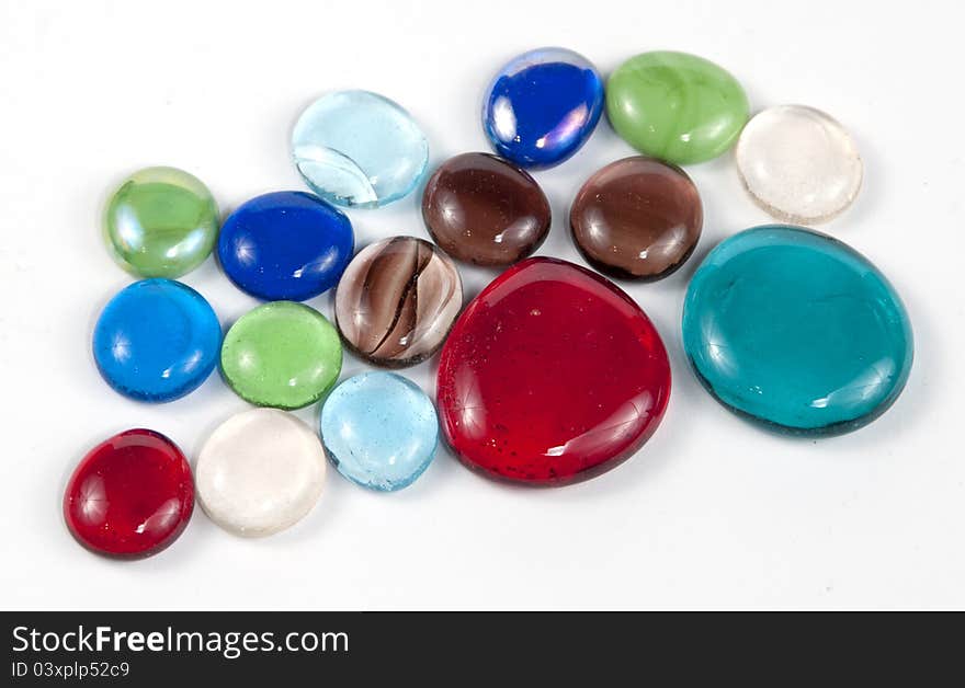 Decorative glass pebbles over white background