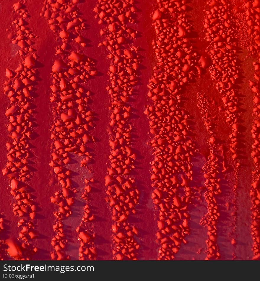 Water drops on red metal