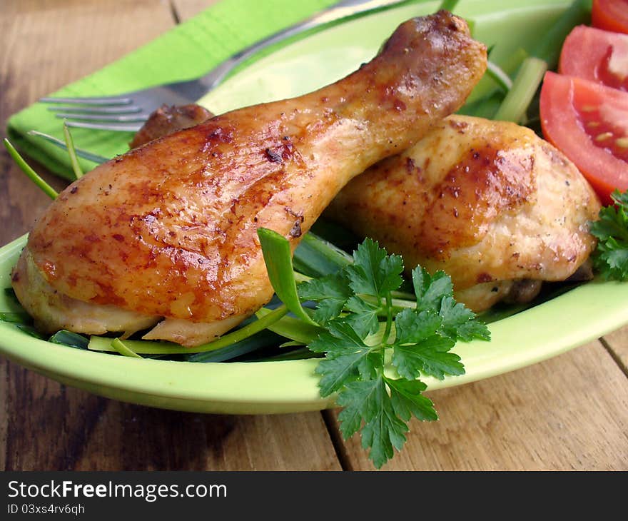 Chicken legs with vegetables on a wooden table