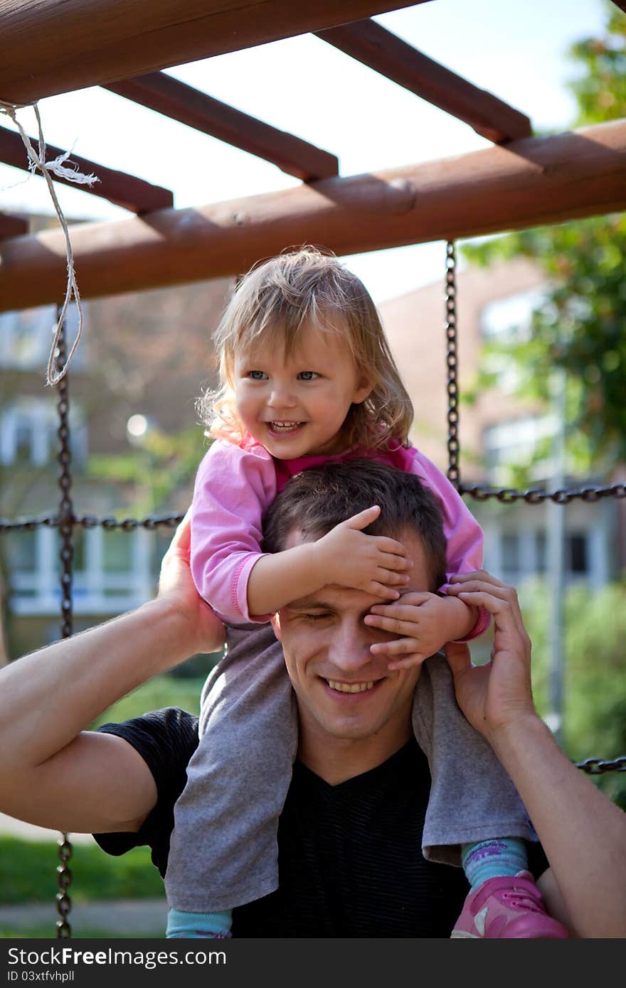 Little girl with her father is spending time at the park. Little girl with her father is spending time at the park.