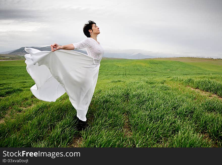 Woman wearing a wedding dress in the field in Granada, Andalusia, Spain. Woman wearing a wedding dress in the field in Granada, Andalusia, Spain