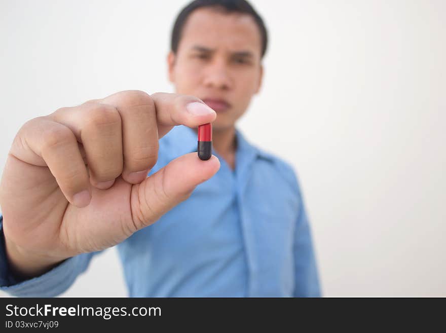 Young doctor showing the pill on his hand