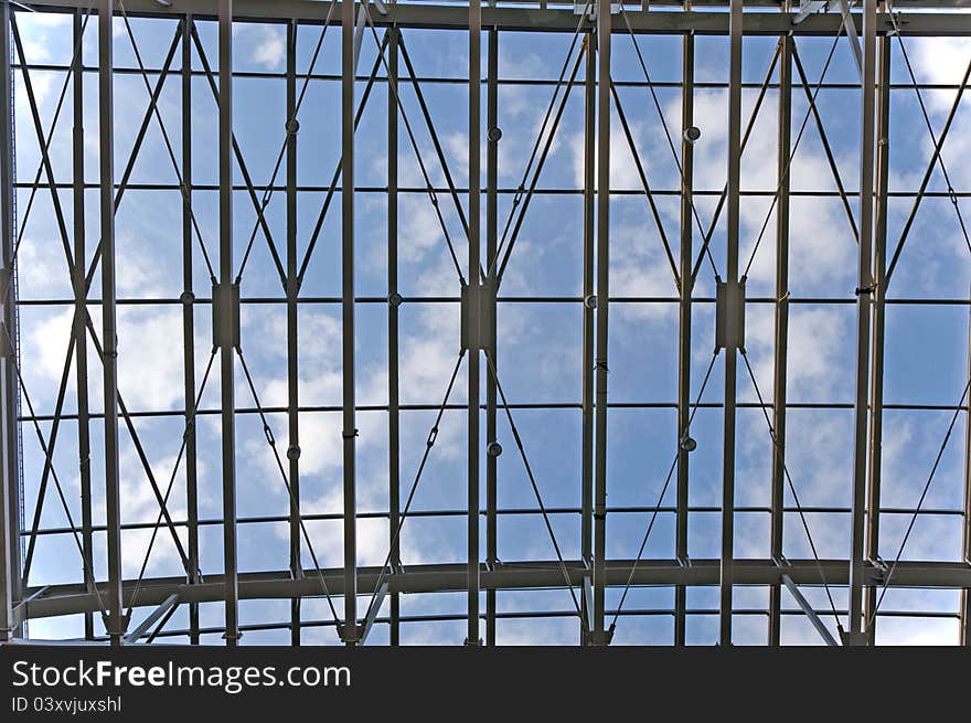 Blue sky with white clouds viewed through a metal ceiling construction. Blue sky with white clouds viewed through a metal ceiling construction