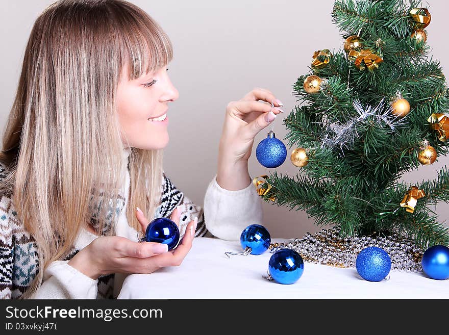 Young woman decorates a Christmas tree. Young woman decorates a Christmas tree