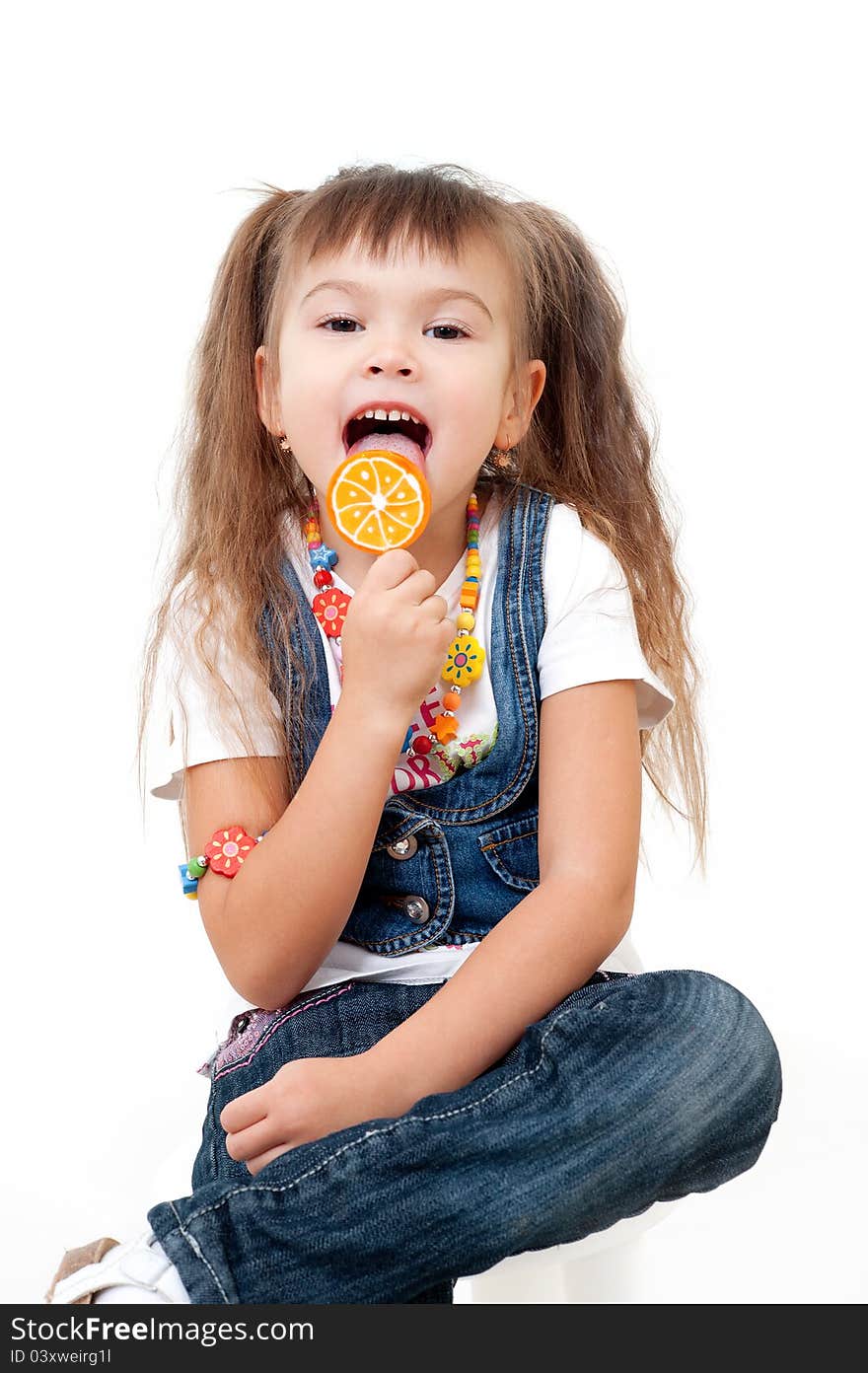 Attractive girl tasting orange candy on stick isolated on white. Attractive girl tasting orange candy on stick isolated on white