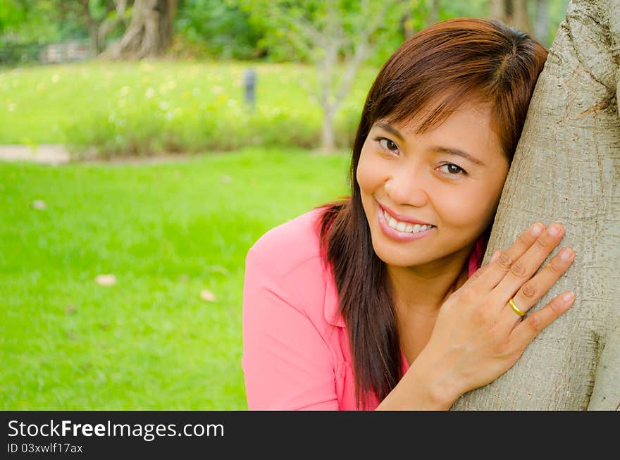 Girl smiling under a tree in park