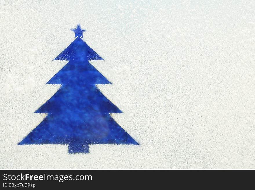 Photography of a Christmas Tree on a frozen window. Symbol of new year.