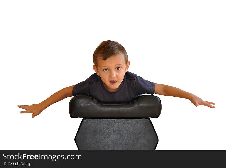 A boy lies on a soft black stools.