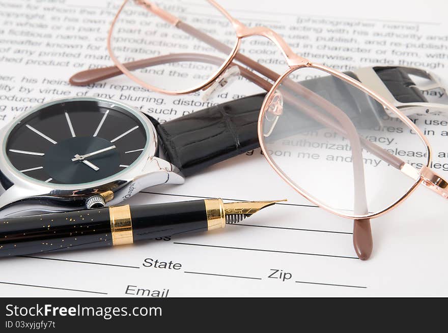 Eyeglasses and pen and wristwatch