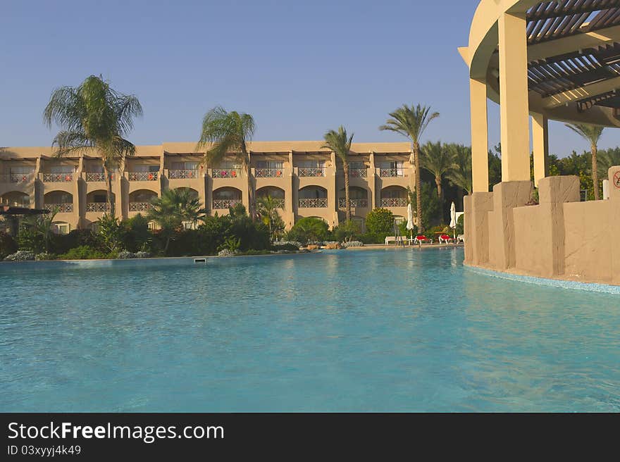 Luxury Resort Pool with palm trees in the early morning light. Luxury Resort Pool with palm trees in the early morning light.