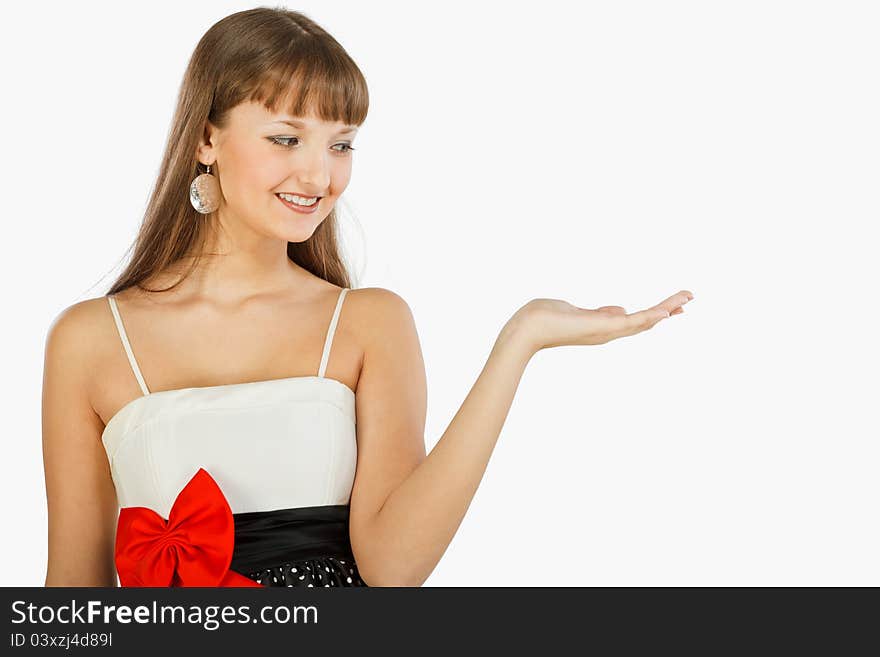 Beautiful smiling fashion girl Showing, Giving Or Presenting. She looks at her hand (the subject of a presentation). Landscape. Black skirt with white polka dots. Topic white with a red bow at the waist. White background. Beautiful smiling fashion girl Showing, Giving Or Presenting. She looks at her hand (the subject of a presentation). Landscape. Black skirt with white polka dots. Topic white with a red bow at the waist. White background.