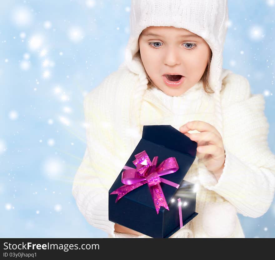 Little girl in cap opens the box